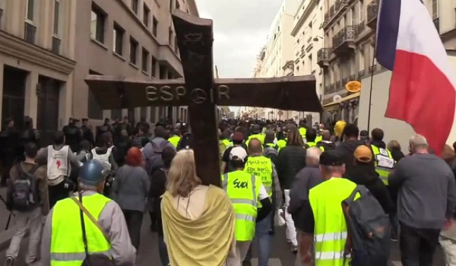 Jezus z krzyżem i młoda para. 46. marsz &#039;żółtych kamizelek&#039; w Paryżu