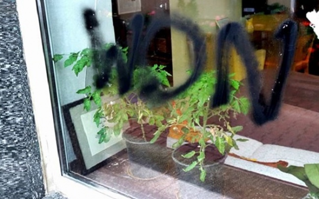 Bezczelny napis na szybie okna kawiarni w Warszawie